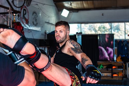 Free A skilled martial artist practices a powerful kick in an indoor gym setting. Stock Photo