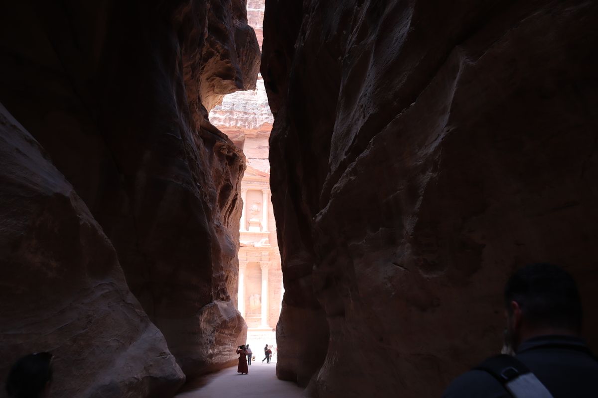 The Treasury at Petra glimpsed from the end of the narrow Siq canyon