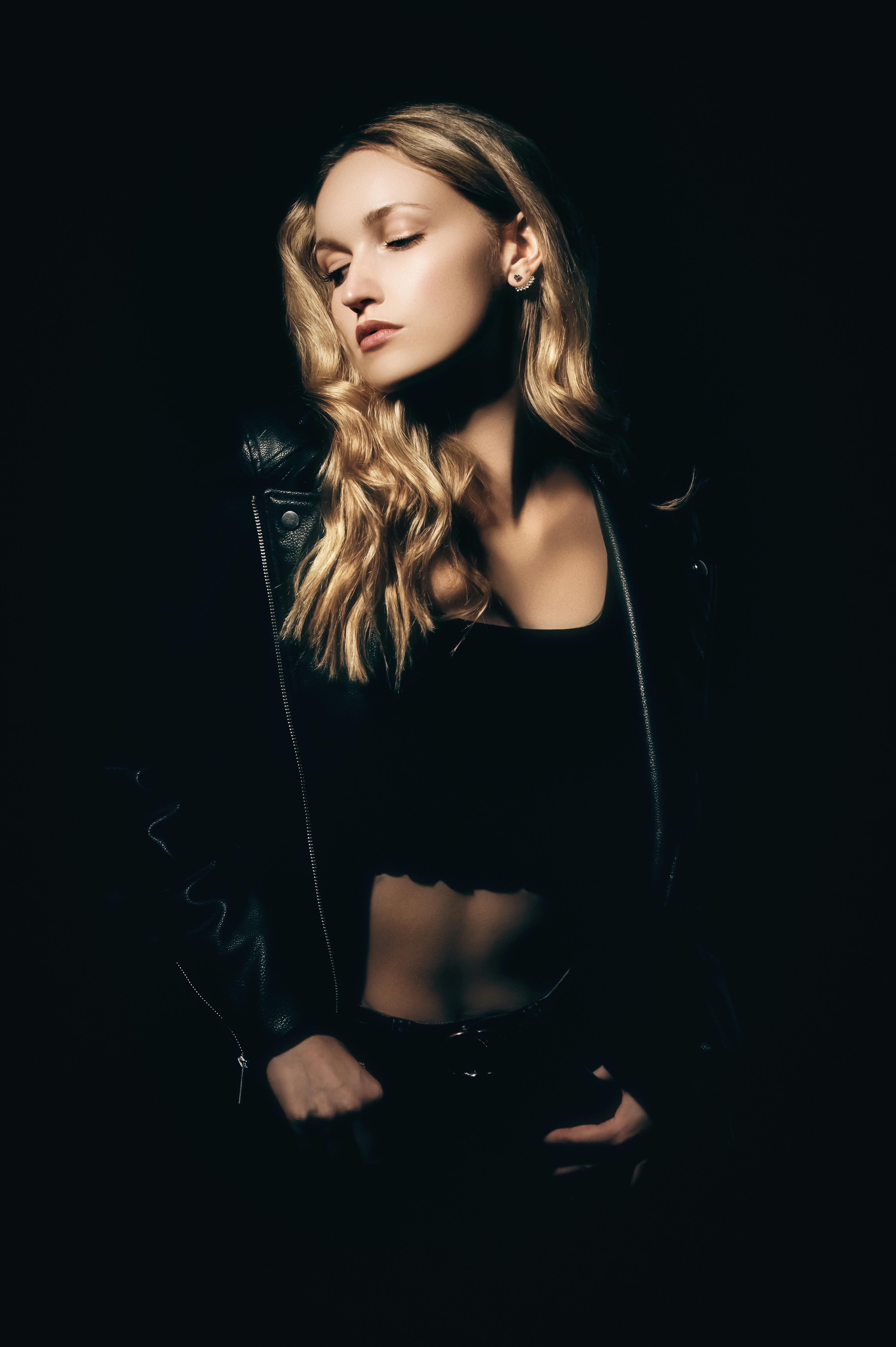 Elegant studio portrait of a woman in a leather jacket with dynamic lighting.