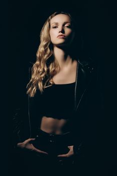 Chic and edgy portrait of a young woman posing confidently in a studio setting.