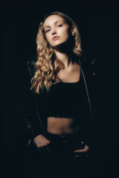 Stylish portrait of a young woman in black attire, exuding confidence.
