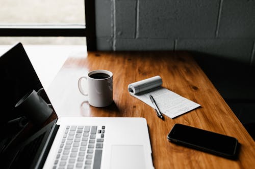 Free Macbook Pro on Brown Wooden Table Stock Photo