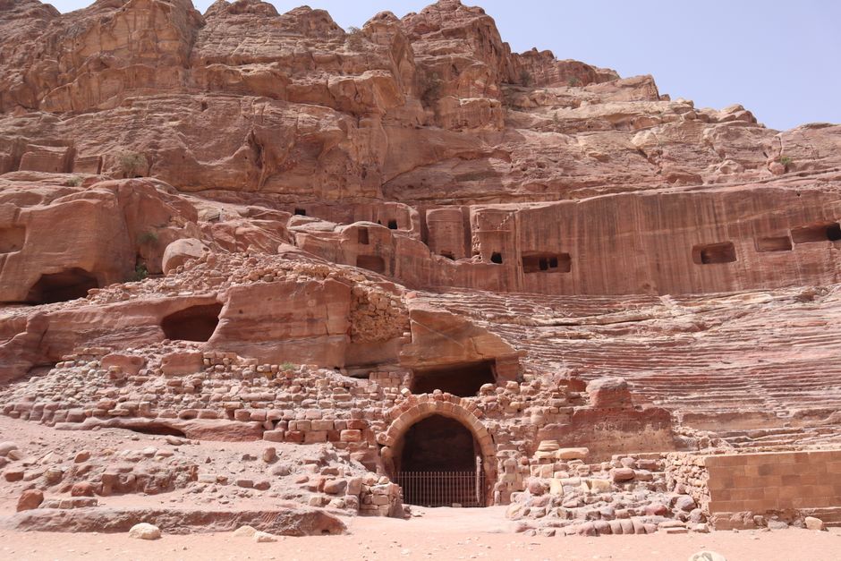 A Jordan Pass booklet displayed against a backdrop of the ancient city of Petra, Jordan, symbolizing cost-effective travel.