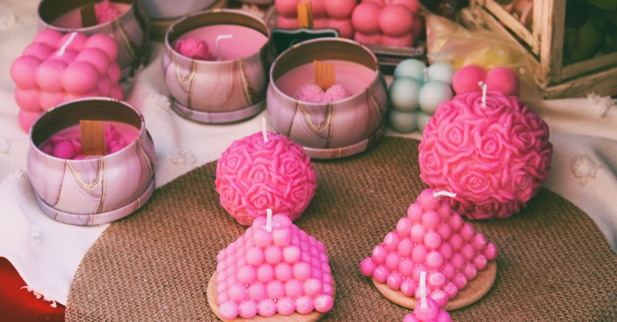 colorful array of handmade candles with books in background, cozy aesthetic