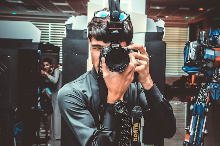 Photo Of Man Using His Nikon Camera