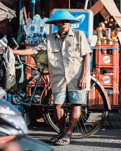 Mann, Der Braunes Hemd Neben Blauem Fahrrad Trägt