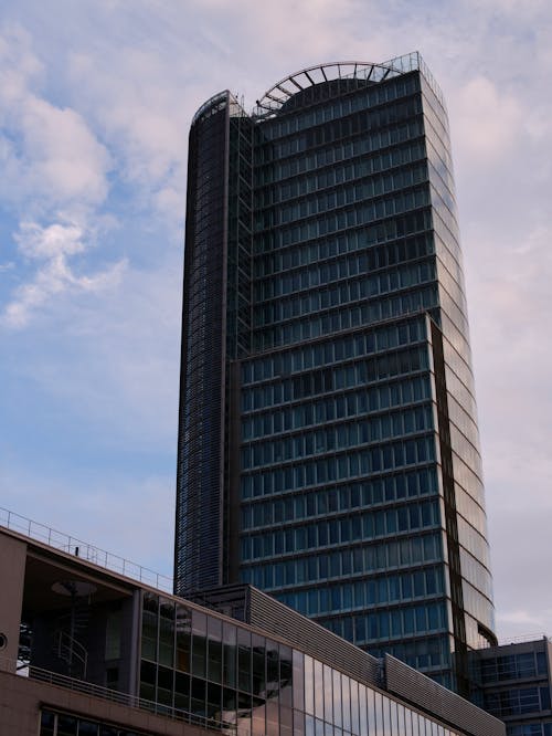 A tall building with a glass roof and a blue sky