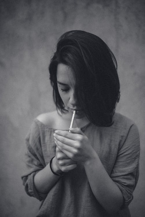 Free Grayscale Photo of Woman Lighting Cigarette Stock Photo