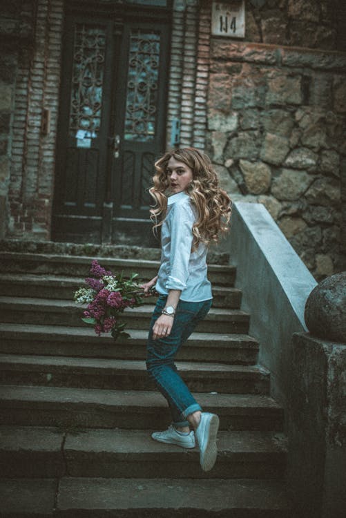 Woman Wearing Dress Shirt While Holding Bouquet of Flowers