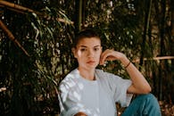 夏日里，一个女人沉思地坐在竹林中的户外时尚肖像