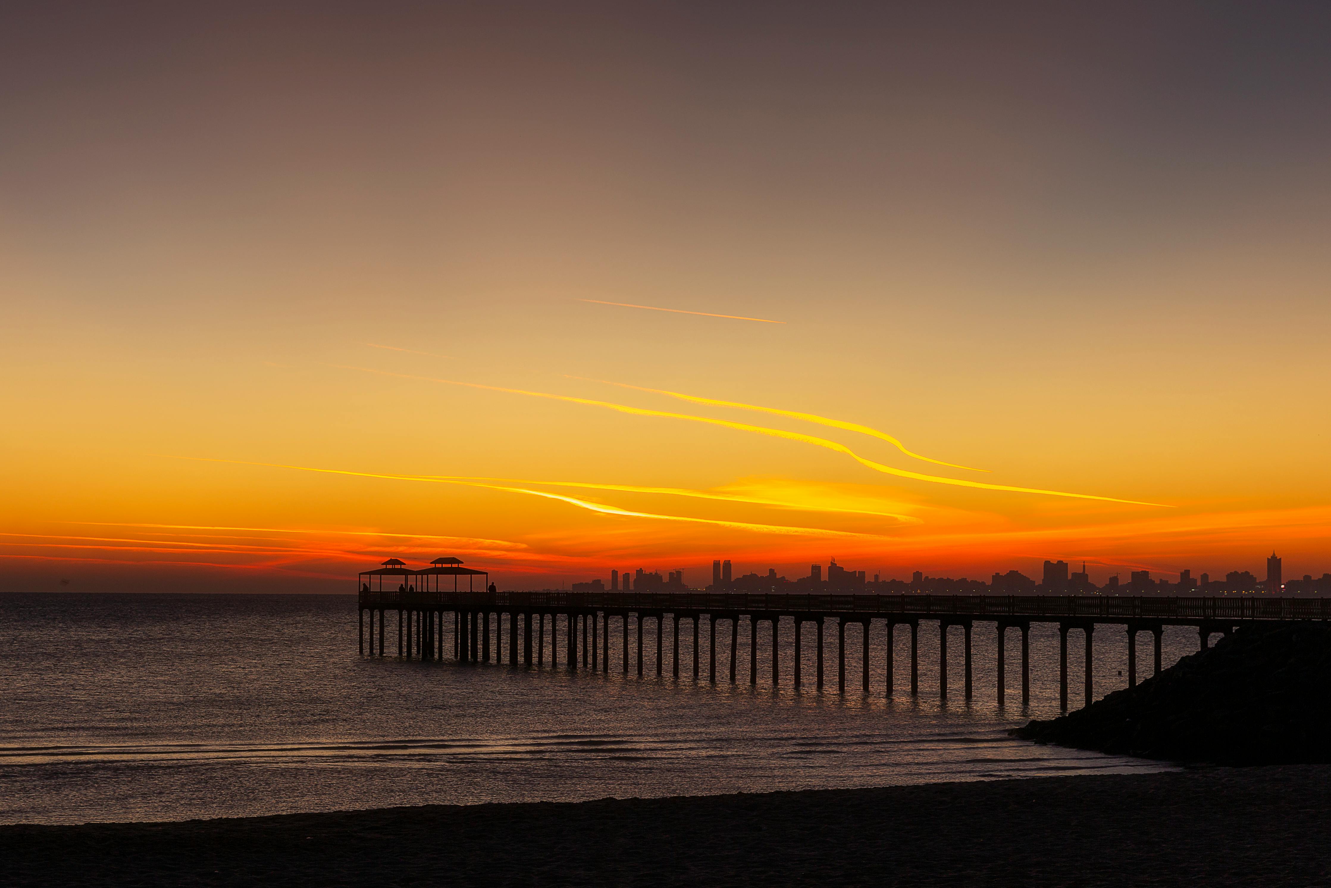 科威特库韦特宁静的码头上，日落景象令人惊叹，天空充满活力，大海一片平静