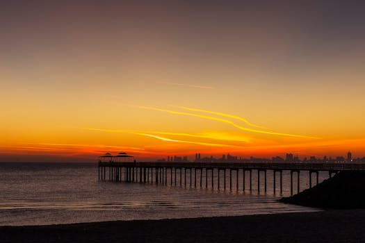 科威特库韦特宁静的码头上，日落景象令人惊叹，天空充满活力，大海一片平静