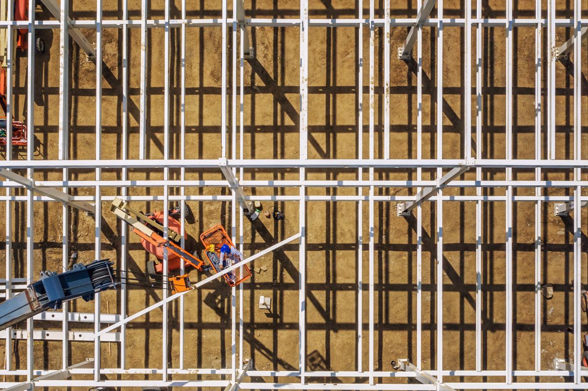 Aerial view of a steel-frame building under construction showing beams and columns