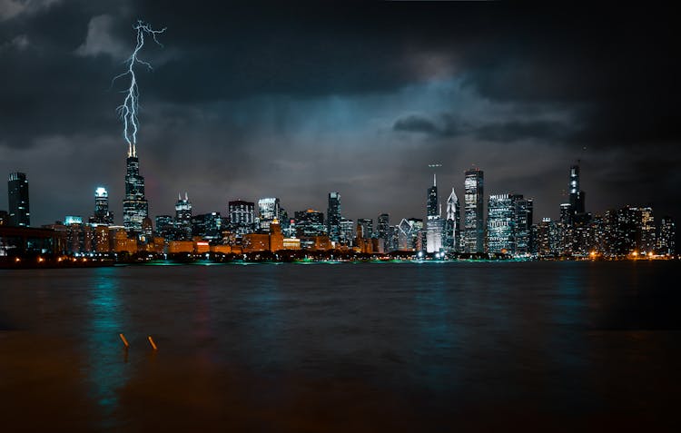 Photo Of Chicago Cityscape At Night While Lightning Strikes High Rise Building