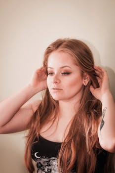 一位年轻女子的美丽肖像，红发飘逸，纹身点缀，尽显自然优雅