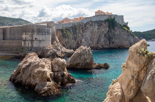 Free Capture of Dubrovnik's historic city walls and coastline, featuring Bokar Fortress and Adriatic Sea. Stock Photo
