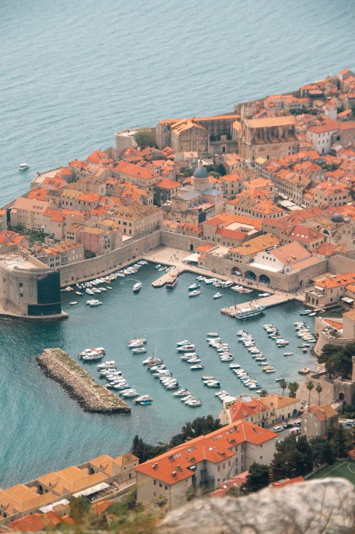 Free Captivating aerial view of Dubrovnik's marina and iconic red rooftops nestled by the Adriatic Sea. Stock Photo