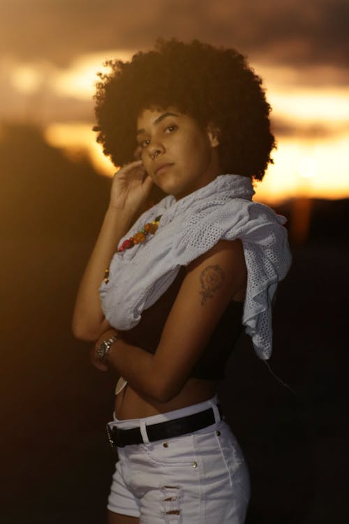 Photo of Woman in White Shorts, Black top, and White Scarf Posing