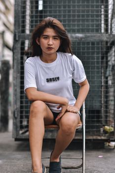 城市环境中，一位年轻女子坐在折叠椅上的休闲肖像