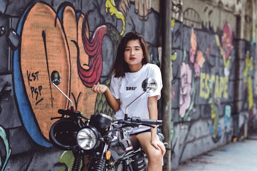 오토바이에 앉아있는 여자의 사진