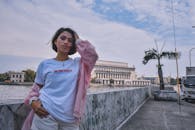 河边都市风景映衬下摆姿势的妇女时尚画像