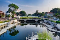 印度尼西亚雅加达市中心的城市运河景色优美，水面上倒映着建筑物和树木