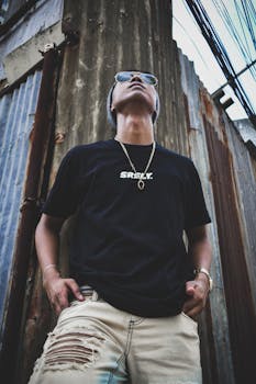 男模特自信地站在防锈金属背景前，摆出时尚的姿势