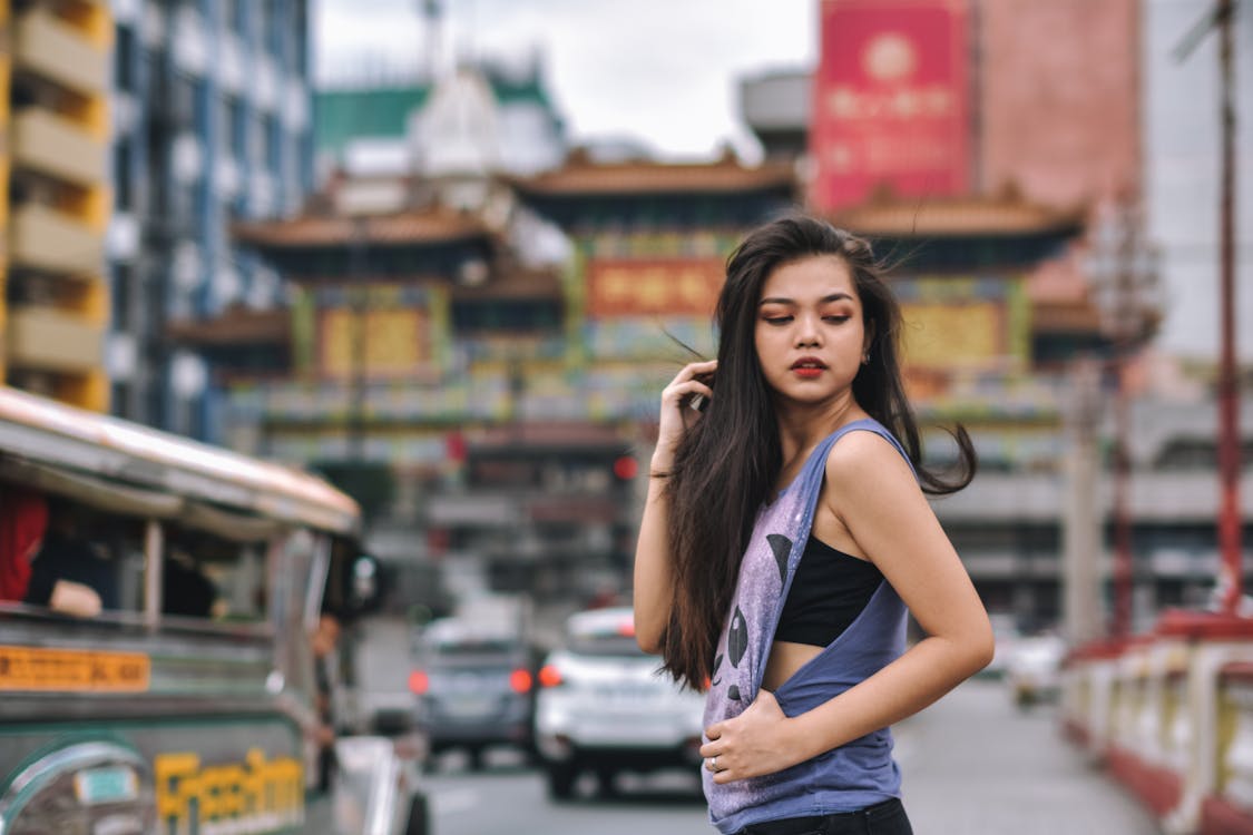 무료 도시 건물에 걸쳐 보라색 민소매 셔츠를 입고 여자 스톡 사진