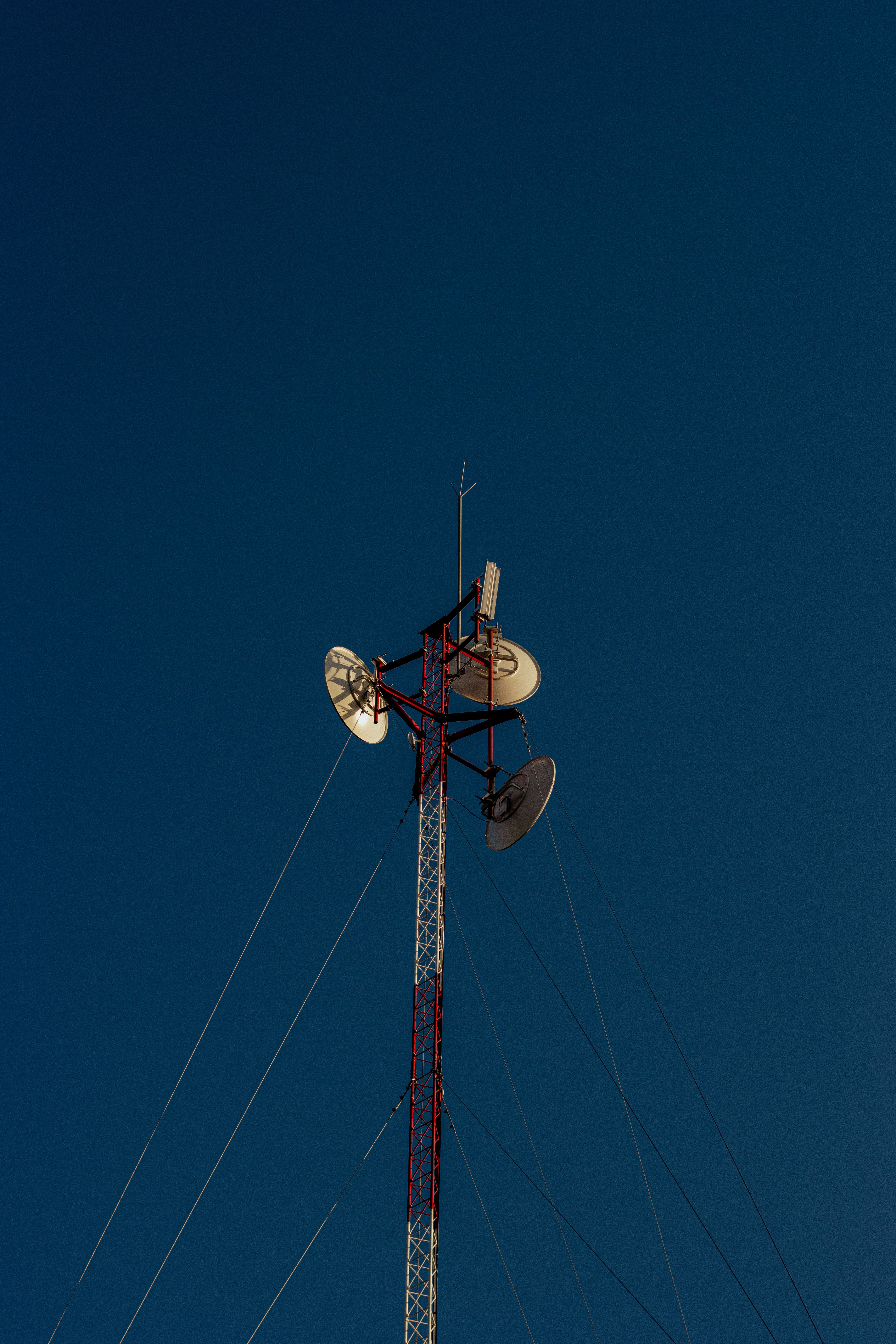 A tall communication tower with satellite dishes against a clear blue sky in Bulnes, Chile.