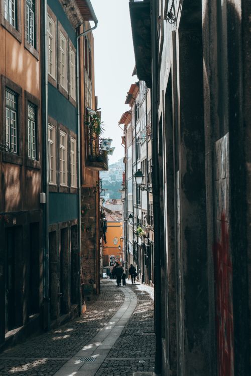 Free Scenic alleyway in Porto showcasing traditional architecture with people strolling. Stock Photo