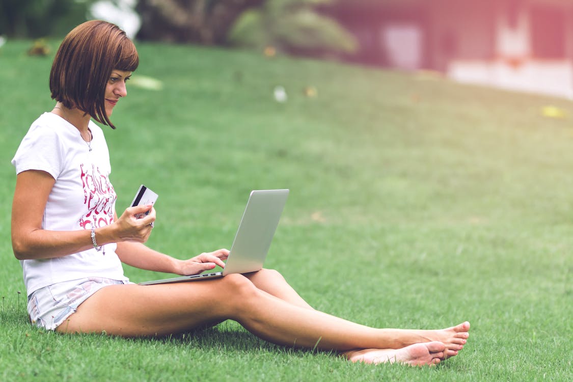 Woman Holding Card With Macbook Air on Lap