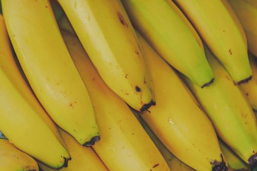 Free Vibrant and fresh close-up of yellow bananas, highlighting their ripe texture and appeal. Stock Photo