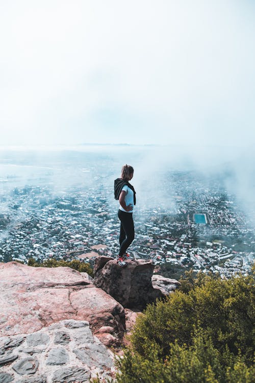 Woman Standing on Brown Rocky Mountain