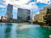 在明亮的天空下，拉斯维加斯的天际线展现出壮丽的景色，现代建筑与清澈的蓝色海水交相辉映