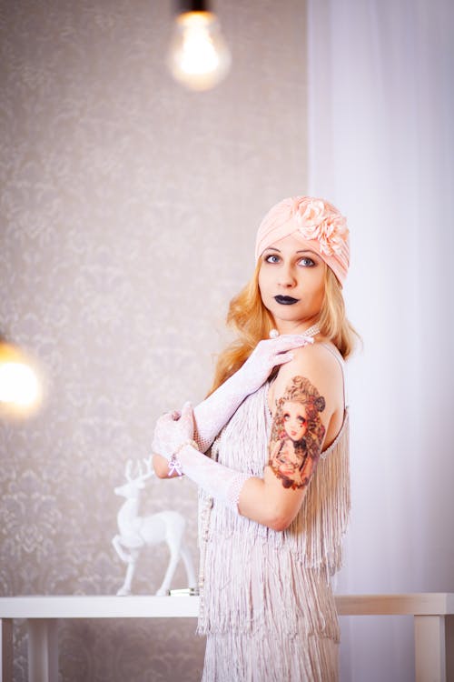 Free Woman Standing Near Wall While Putting Her Hand On Shoulder Stock Photo