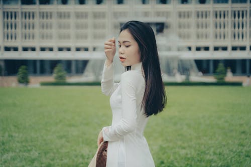 A woman in white dress standing in front of a building