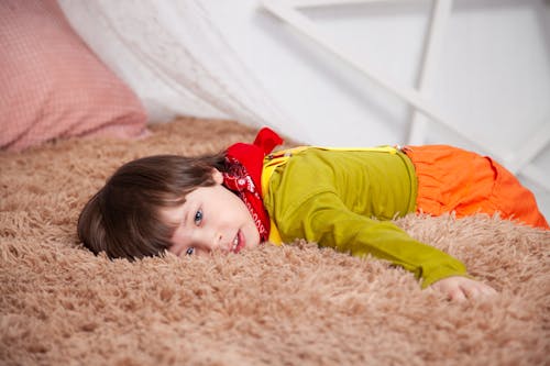Free Child Lying On Brown Fur Textile Stock Photo