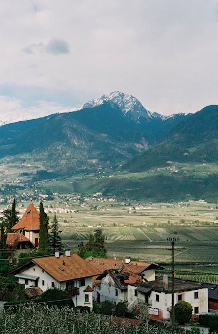 Picturesque countryside in Lana, Italy with vineyards and mountains.