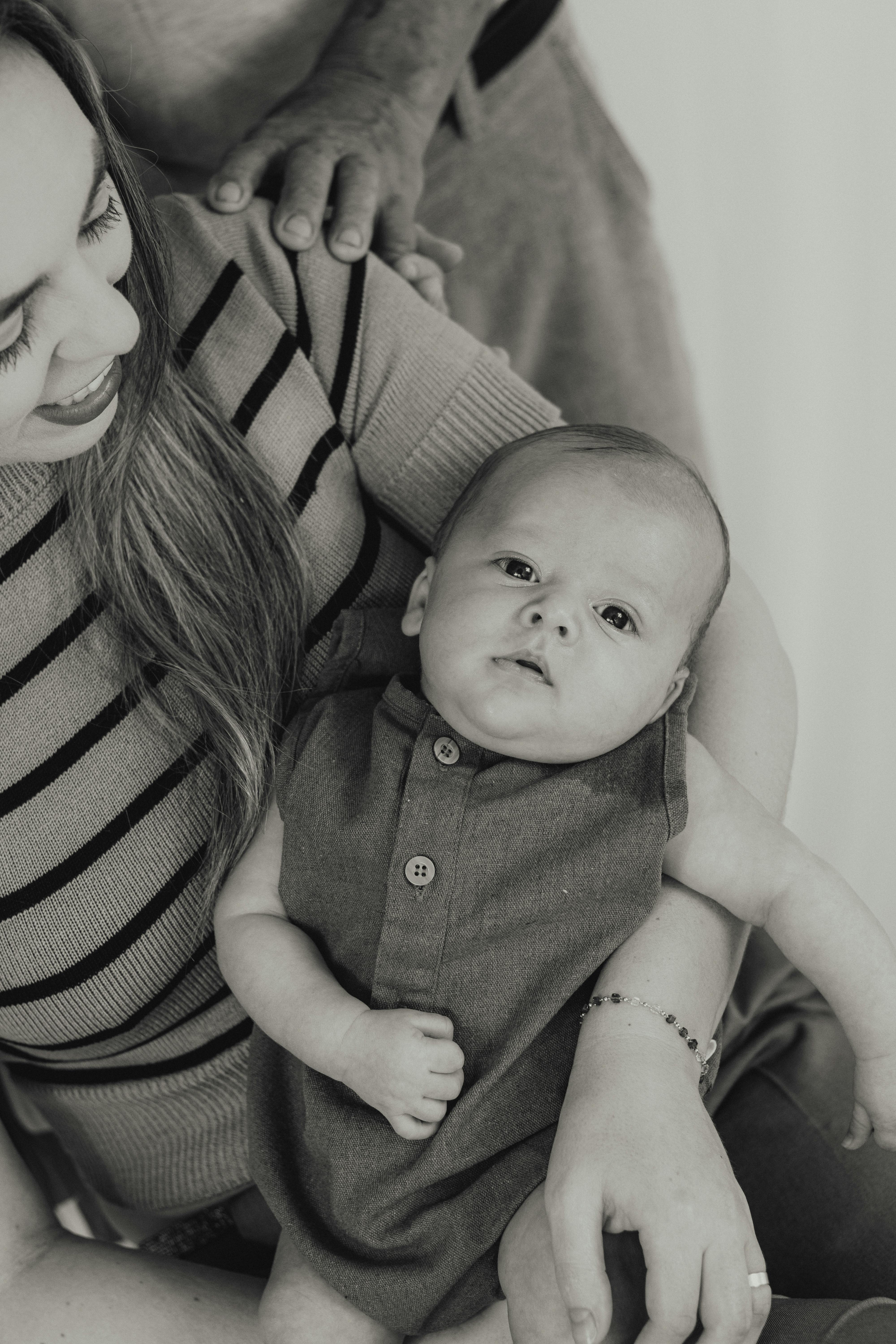 black and white photo of a woman holding her newborn baby