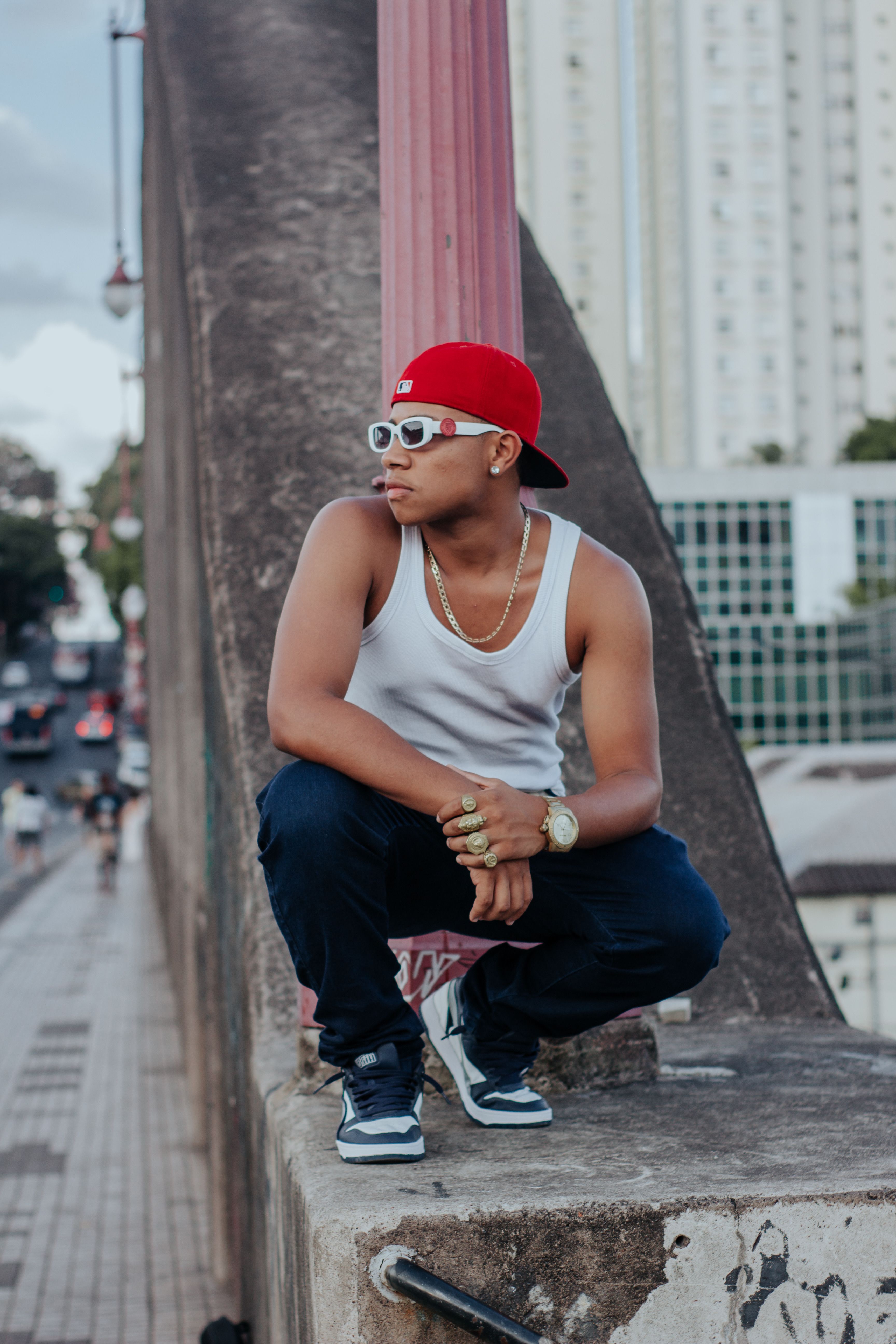 A Young Man in a Casual Outfit Crouching on a Wall in a City · Free ...