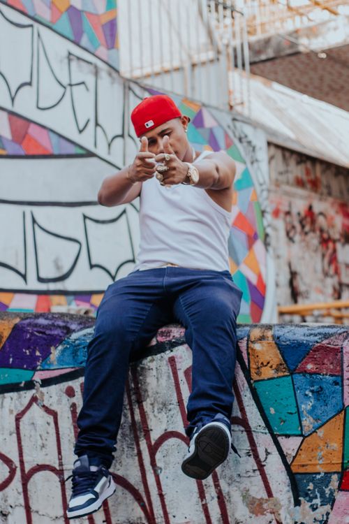 Free Man in casual streetwear posing with colorful graffiti background. Stock Photo