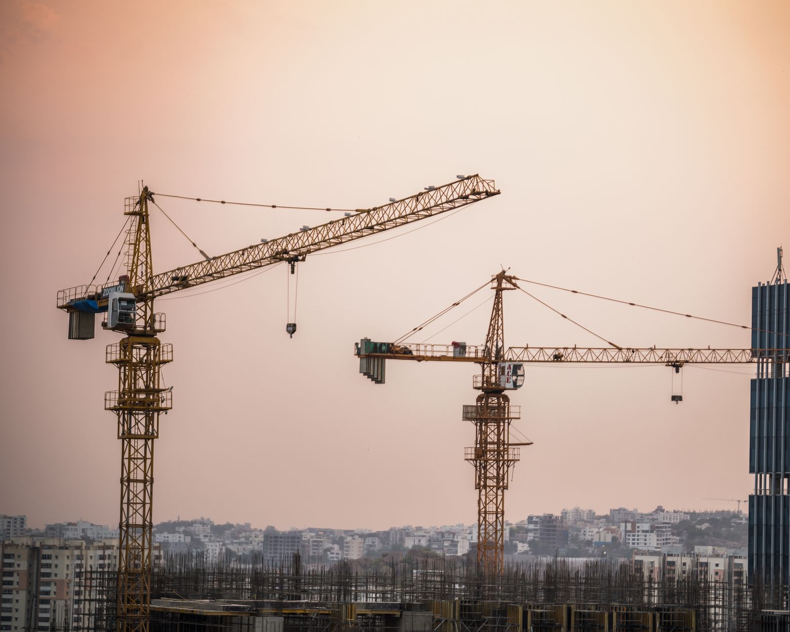 Construction site with tower cranes at dusk