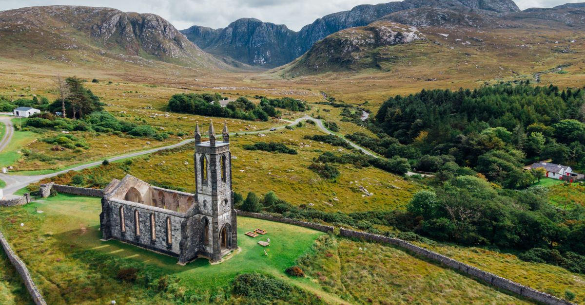 Aerial view of a picturesque abandoned church in County Donegal's lush countryside.