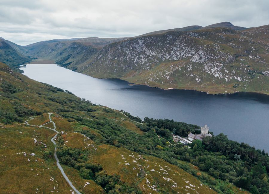 Scenic aerial view of Glenveagh National Park in County Donegal, showcasing a tranquil lake and lush green landscape.