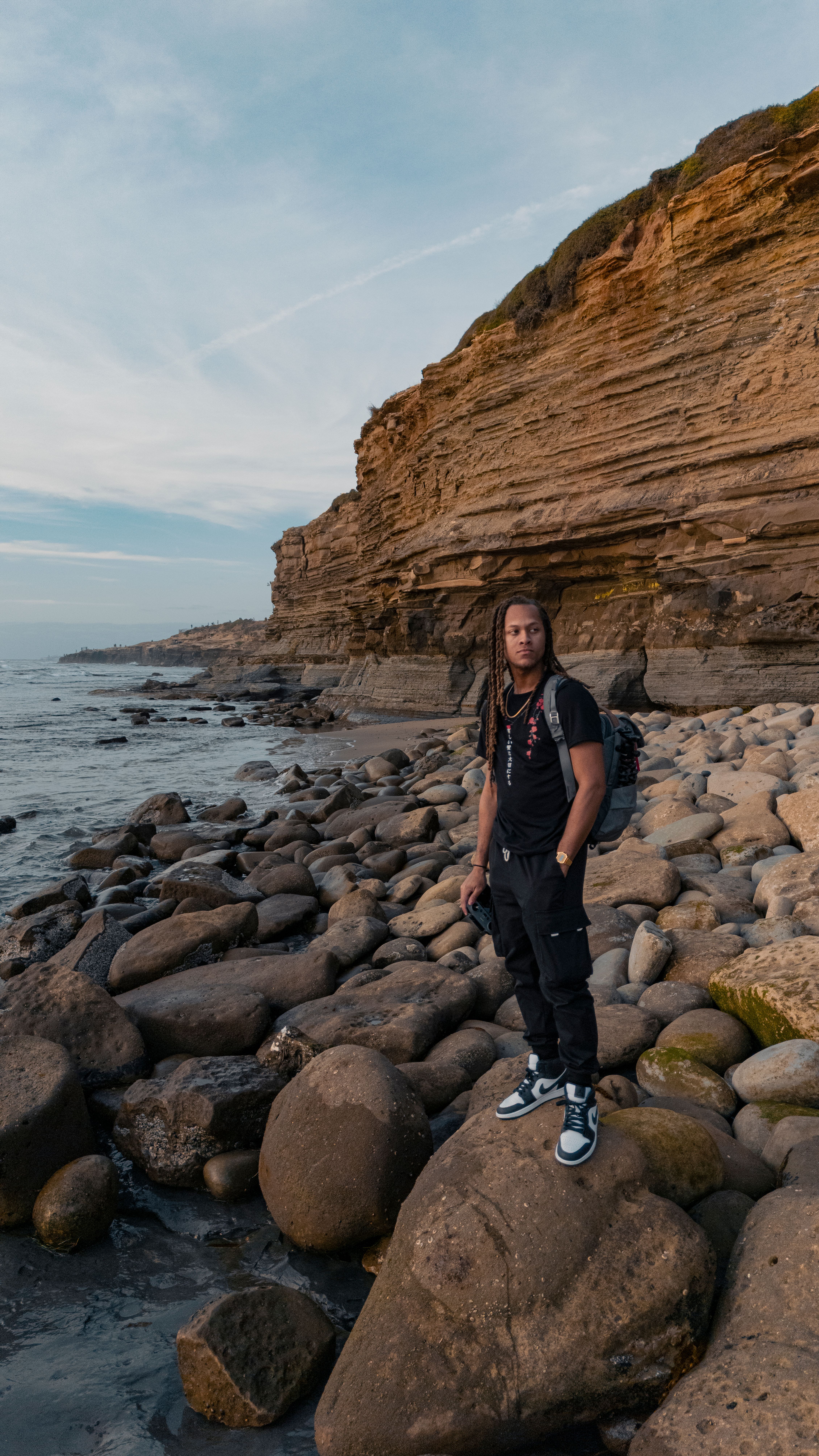 Man Standing on Rocks on Sea Shore · Free Stock Photo