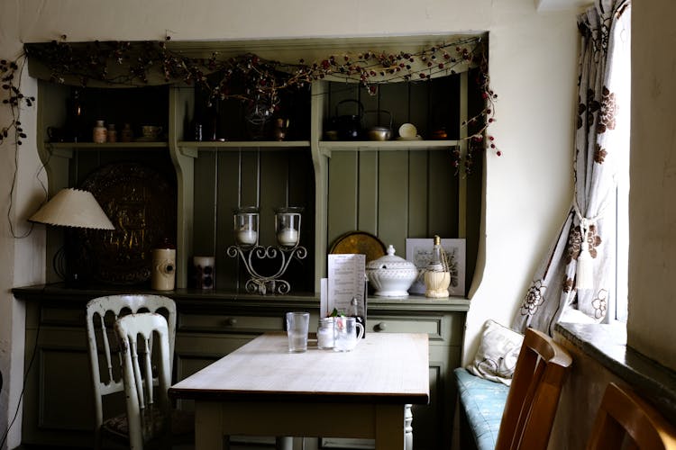 Green Display Cabinet And White Dining Set In A Kitchen