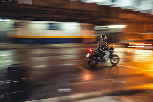 야간 동안 오토바이를 타는 사람의 저속 촬영 사진