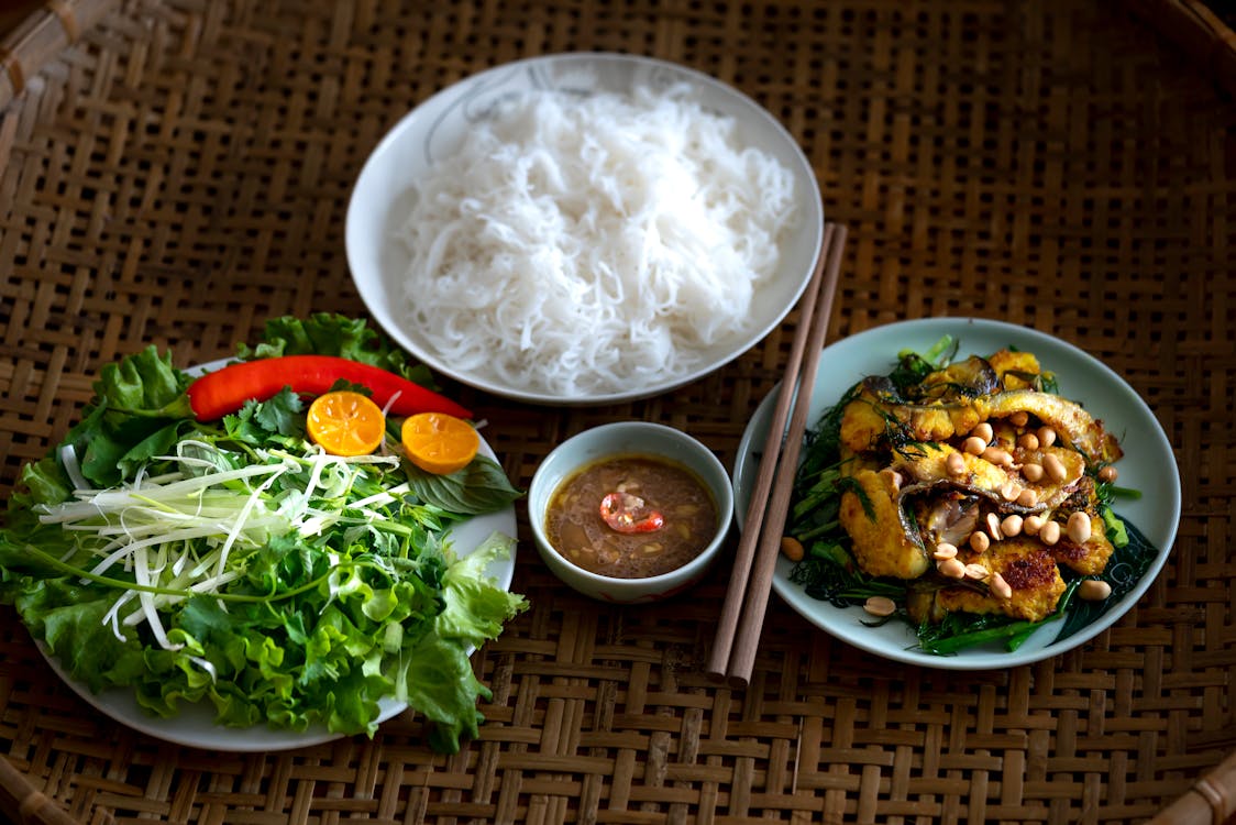 Vegetables and Noodles in Plates on Table