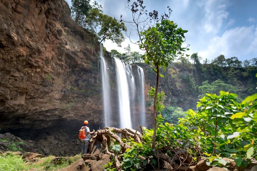 Pria Berdiri Di Depan Air Terjun