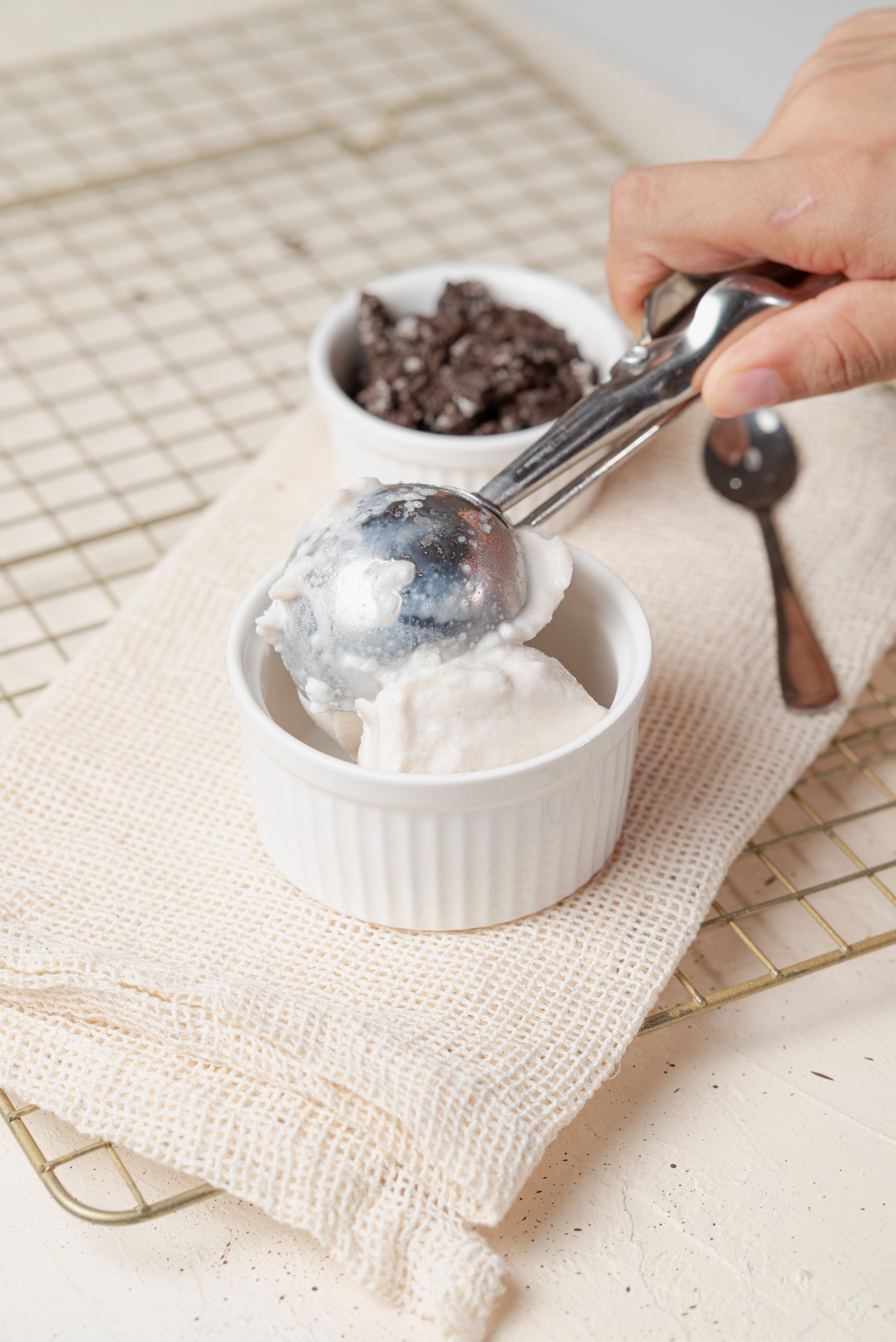 A person scooping a serving of homemade vanilla ice cream